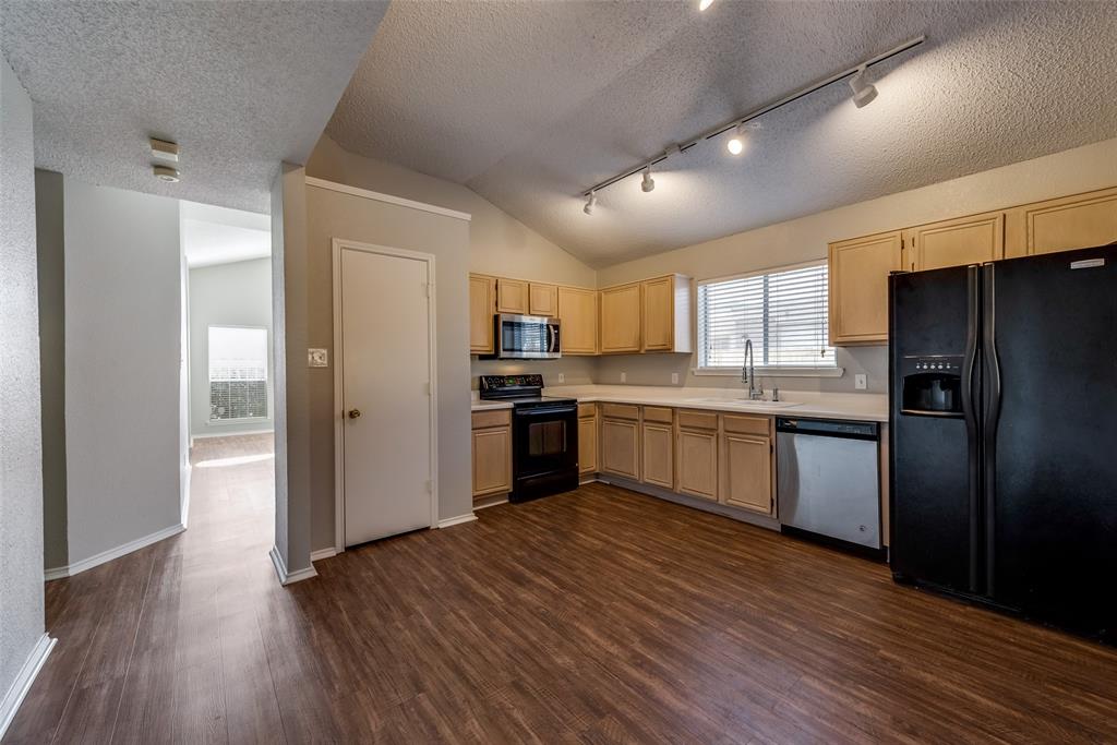 8129 Spruce Valley Drive Fort Worth, TX 76137 - Photo 7 of 19 a kitchen with a refrigerator a sink dishwasher with a oven and cabinets with wooden floor