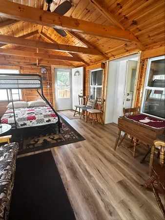 a living room with chairs and wooden floor
