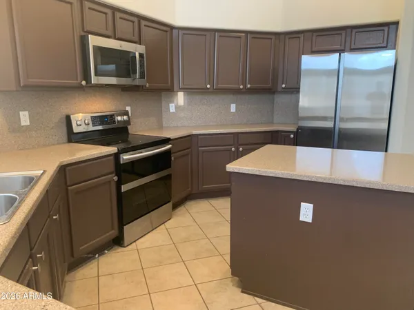 a view of a kitchen with a sink and a refrigerator