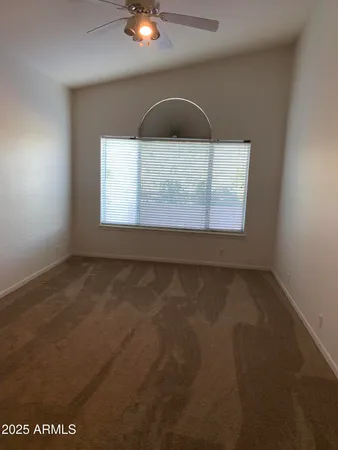 a view of an empty room with a ceiling fan