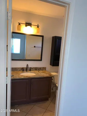 a bathroom with a granite countertop sink mirror vanity bathtub and toilet