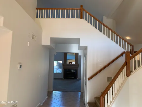 a view of staircase with lots of frames on wall and wooden floor
