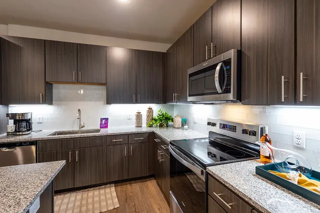 a kitchen with a sink a stove and cabinets
