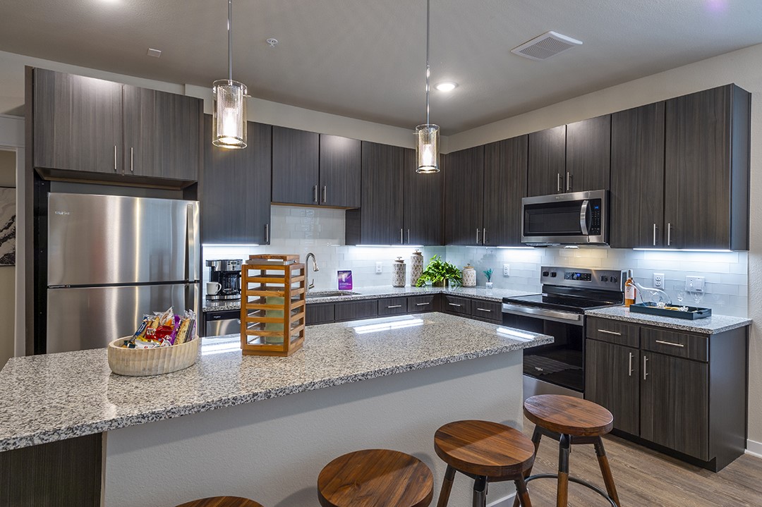 30020 Creekside Ter Drive, Unit 2114 Spring, TX 77386 - Photo 5 of 23 a kitchen with granite countertop a sink stainless steel appliances and cabinets