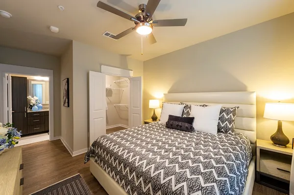 a bedroom with a large bed and a chandelier