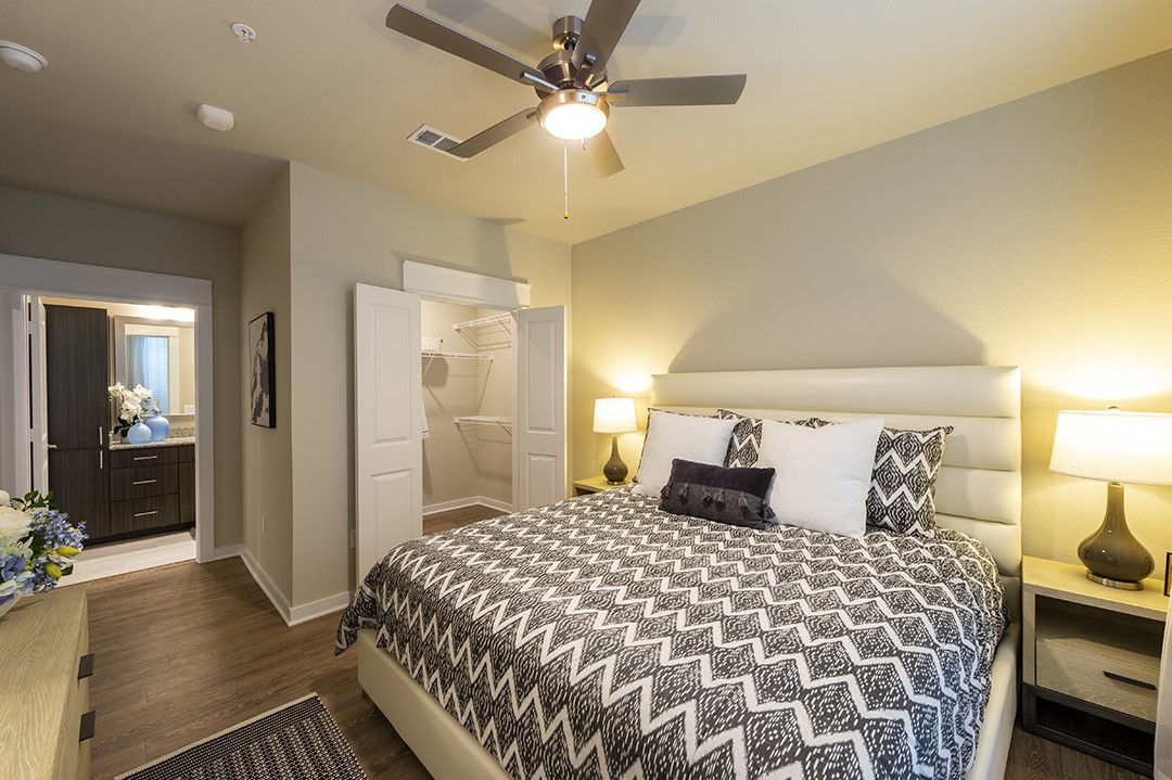 30020 Creekside Ter Drive, Unit 2114 Spring, TX 77386 - Photo 8 of 23 a bedroom with a large bed and a chandelier