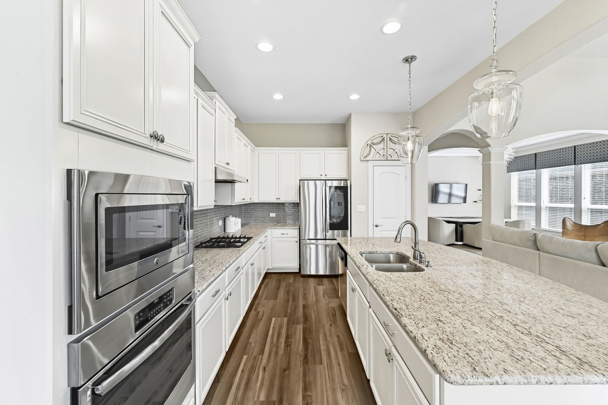 19620 Stanton Drew Pflugerville, TX 78660 - Photo 33 of 33 Kitchen featuring open floor plan, stainless steel appliances, decorative light fixtures, white cabinetry, and a kitchen island with sink