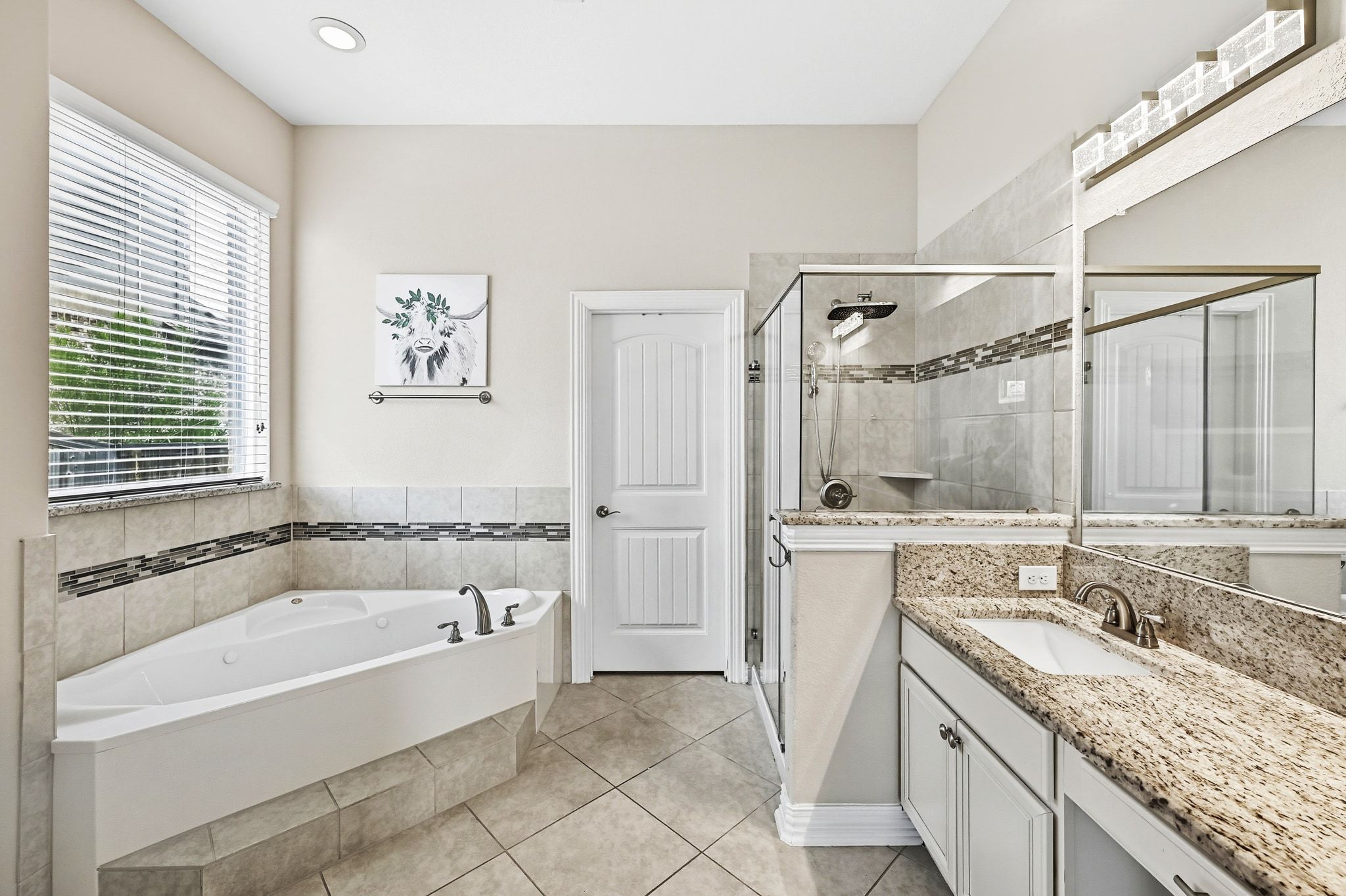 19620 Stanton Drew Pflugerville, TX 78660 - Photo 18 of 33 Full bath with vanity, a stall shower, a garden tub, and light tile patterned floors