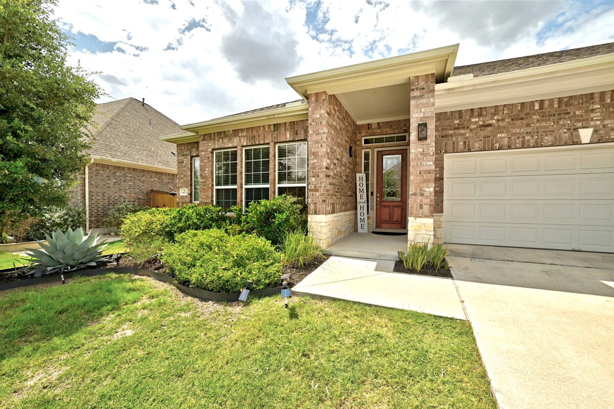 19620 Stanton Drew Pflugerville, TX 78660 - Photo 2 of 33 Entrance to property with brick siding, driveway, a garage, and a yard
