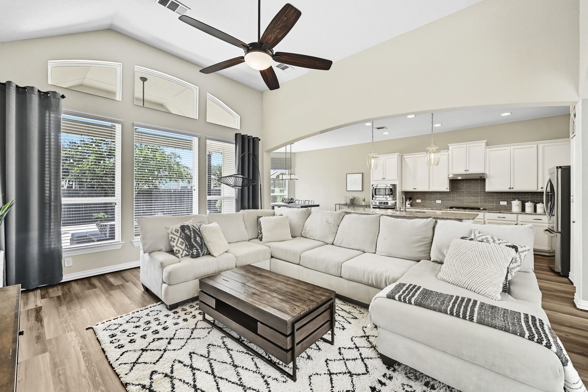 19620 Stanton Drew Pflugerville, TX 78660 - Photo 2 of 33 Living room featuring a ceiling fan, light wood finished floors, lofted ceiling, and arched walkways