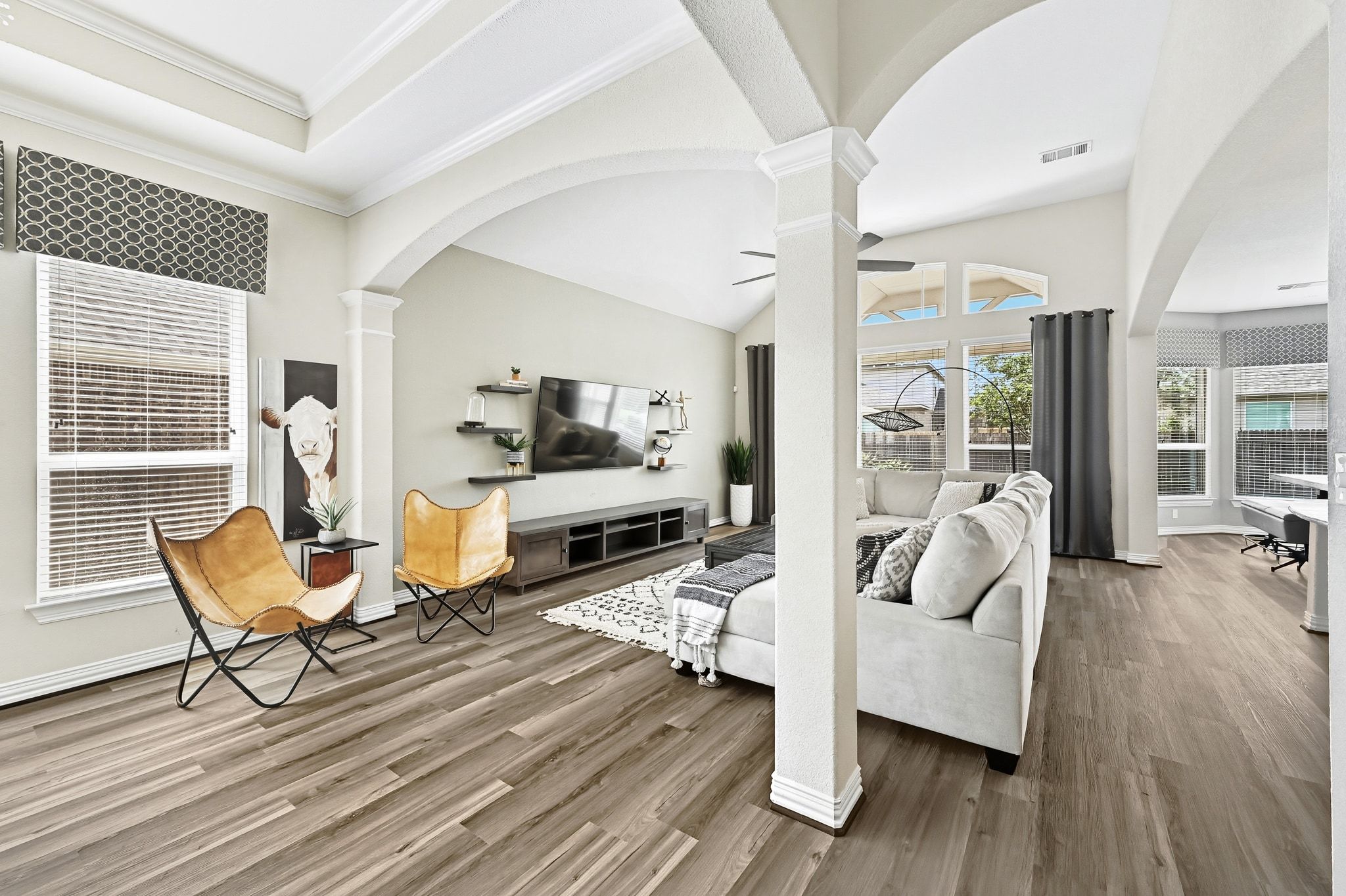 19620 Stanton Drew Pflugerville, TX 78660 - Photo 6 of 33 Living room featuring arched walkways, ornate columns, wood finished floors, and crown molding