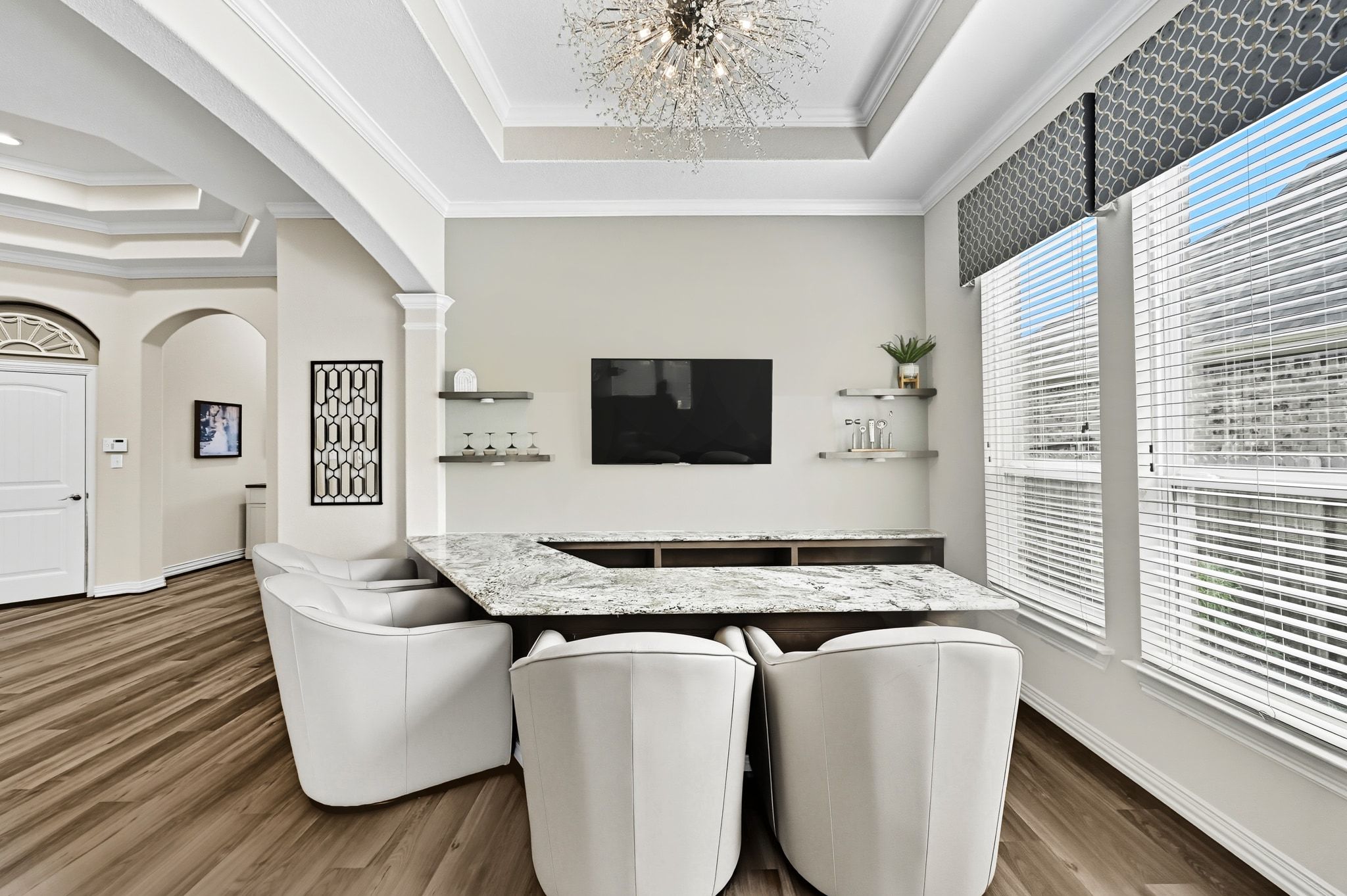19620 Stanton Drew Pflugerville, TX 78660 - Photo 9 of 33 Dining space featuring a tray ceiling, arched walkways, ornamental molding, dark wood-type flooring, and suspended lighting