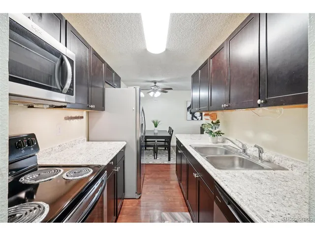 a kitchen that has a sink a stove and chairs