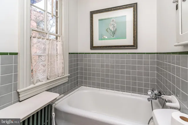 a bathroom with a bathtub and next to a window