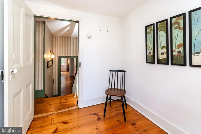 a view of a hallway with wooden floor and furniture
