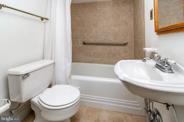 a white toilet sitting next to a bath tub