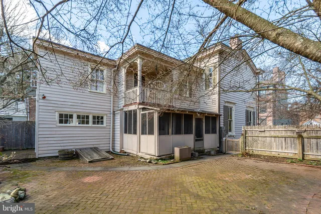 a view of a house with a yard and large tree