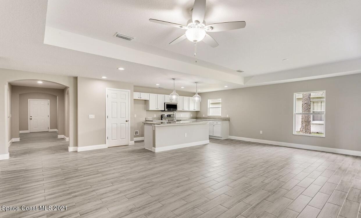 1738 Hydrangea Road Palm Bay, FL 32907 - Photo 11 of 20 a view of an empty room and kitchen with wooden floor