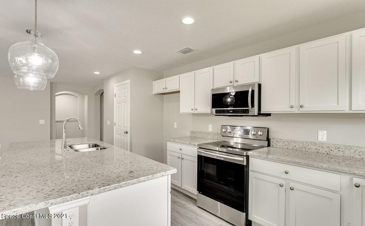 1738 Hydrangea Road Palm Bay, FL 32907 - Photo 13 of 20 a kitchen with appliances a sink and cabinets