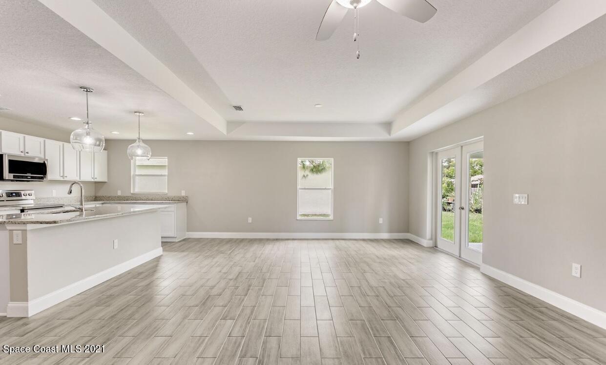 1738 Hydrangea Road Palm Bay, FL 32907 - Photo 10 of 20 a view of an empty room with window and wooden floor