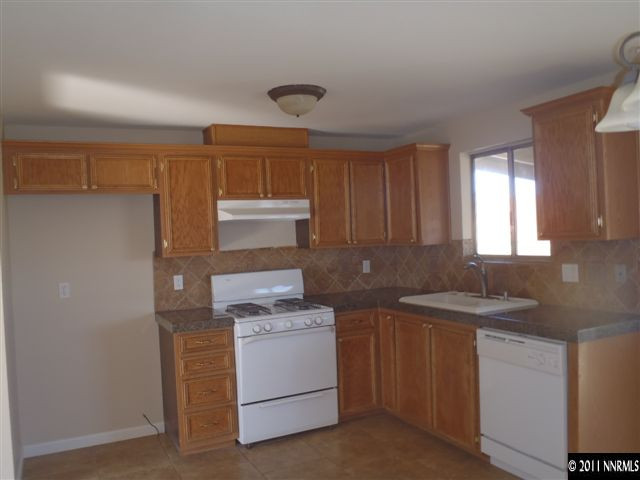 13012 Exinite Drive Reno, NV 89506 - Photo 6 of 12 a kitchen with a sink stove and cabinets