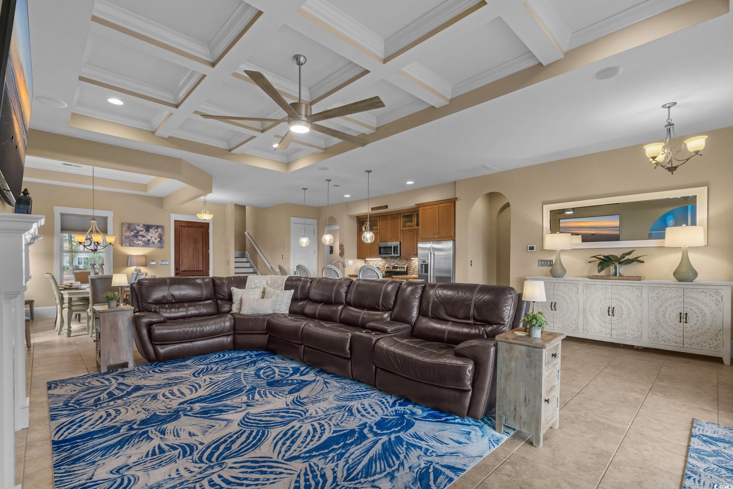 2604 Painted Trillium Court Myrtle Beach, SC 29579 - Photo 12 of 40 Living area featuring a chandelier, ceiling fan, light tile patterned floors, coffered ceiling, and crown molding