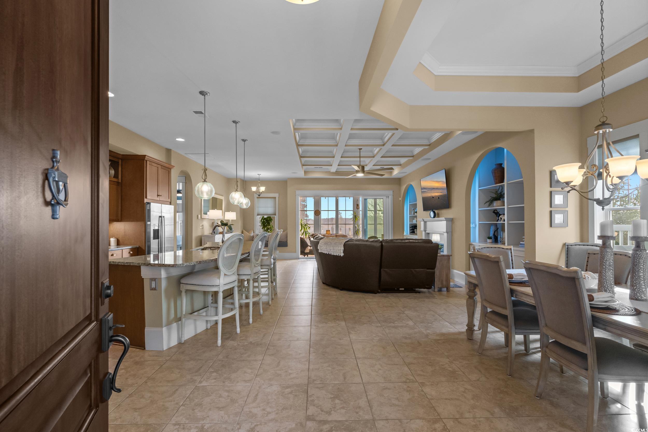 2604 Painted Trillium Court Myrtle Beach, SC 29579 - Photo 3 of 40 Dining area featuring a chandelier, coffered ceiling, a ceiling fan, beam ceiling, and light tile patterned flooring
