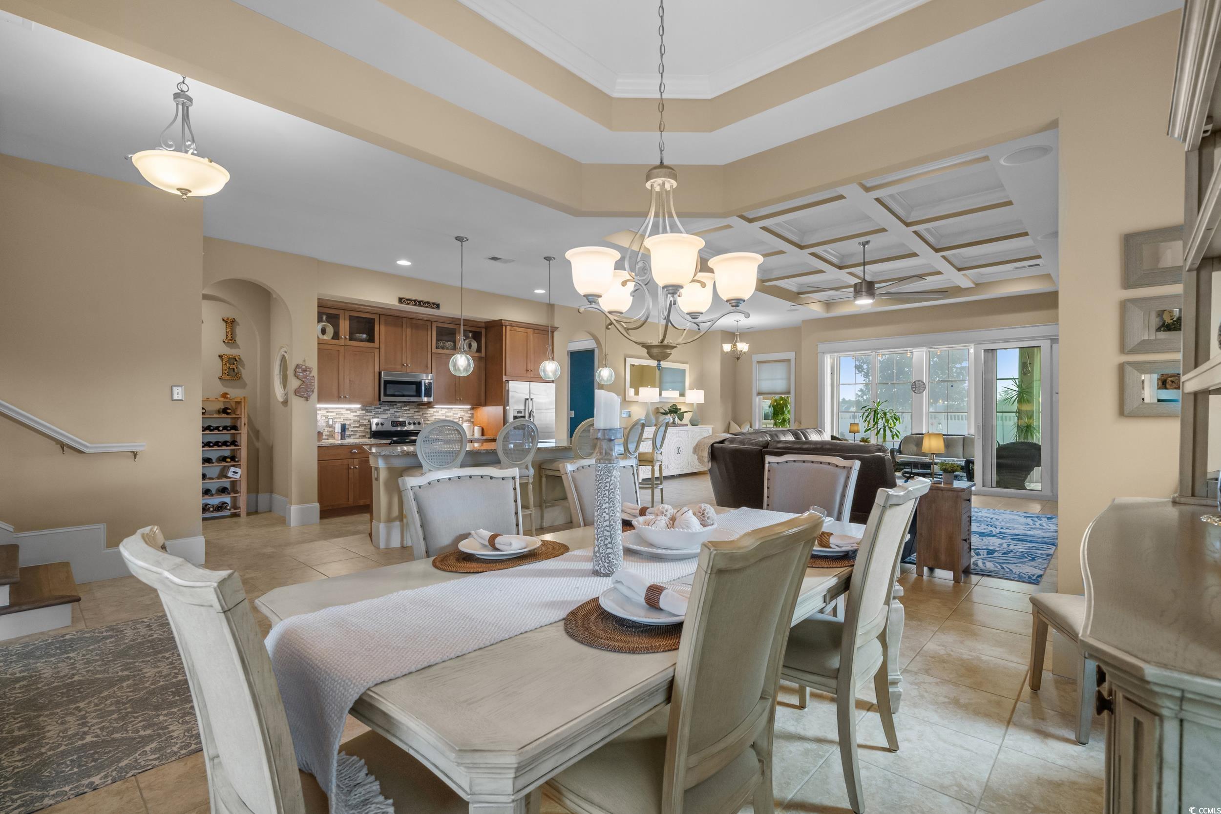 2604 Painted Trillium Court Myrtle Beach, SC 29579 - Photo 7 of 40 Dining room featuring light tile patterned floors, arched walkways, a chandelier, coffered ceiling, and a raised ceiling