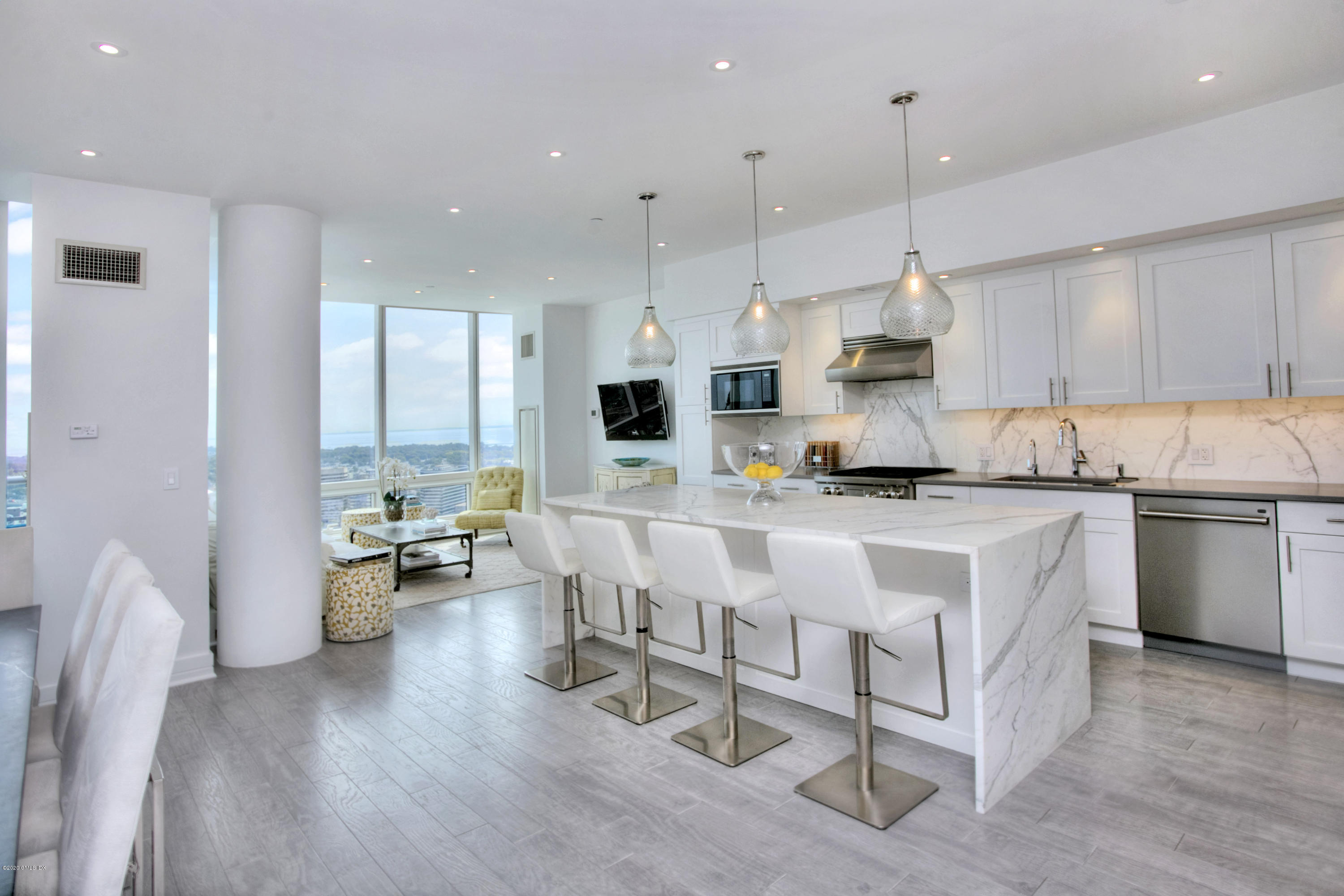 1 Broad Street, Unit PHD4 Stamford, CT 06901 - Photo 10 of 38 a kitchen with stainless steel appliances kitchen island granite countertop a stove a sink a refrigerator and white cabinets with wooden floor