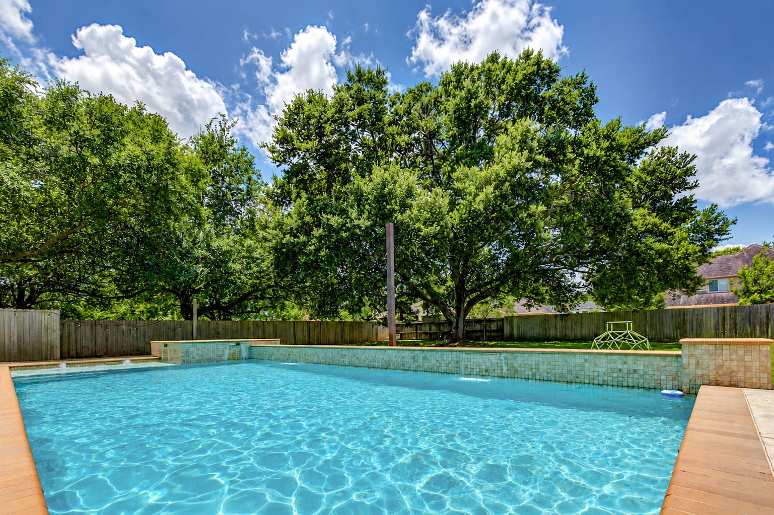 5327 Whitmore Fulshear, TX 77441 - Photo 38 of 50 Cool off during warm Texas summers in the sparkling pool featuring a tanning shelf and recently updated filtration equipment, all surrounded by mature trees for added privacy.