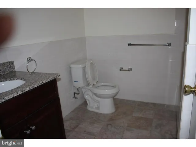 a bathroom with a granite countertop sink toilet and a mirror