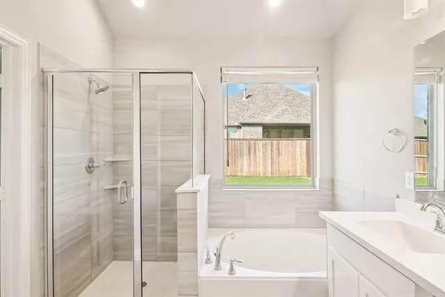 a bathroom with a granite countertop bathtub shower sink and vanity