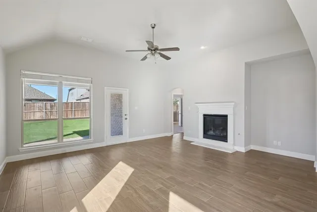 an empty room with windows and fireplace