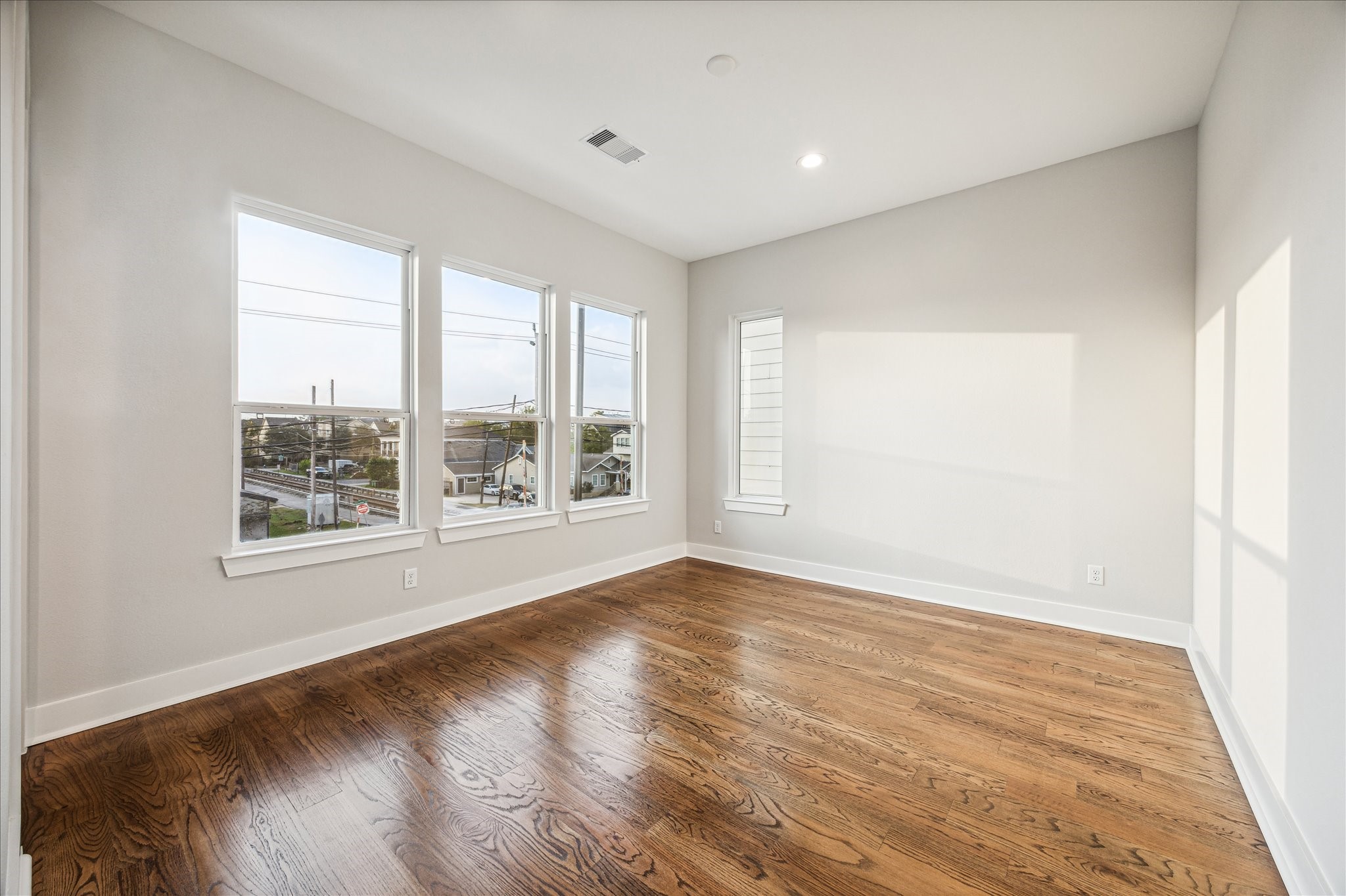 1518 Houston Avenue Houston, TX 77007 - Photo 22 of 40 a view of an empty room with a window and wooden floor