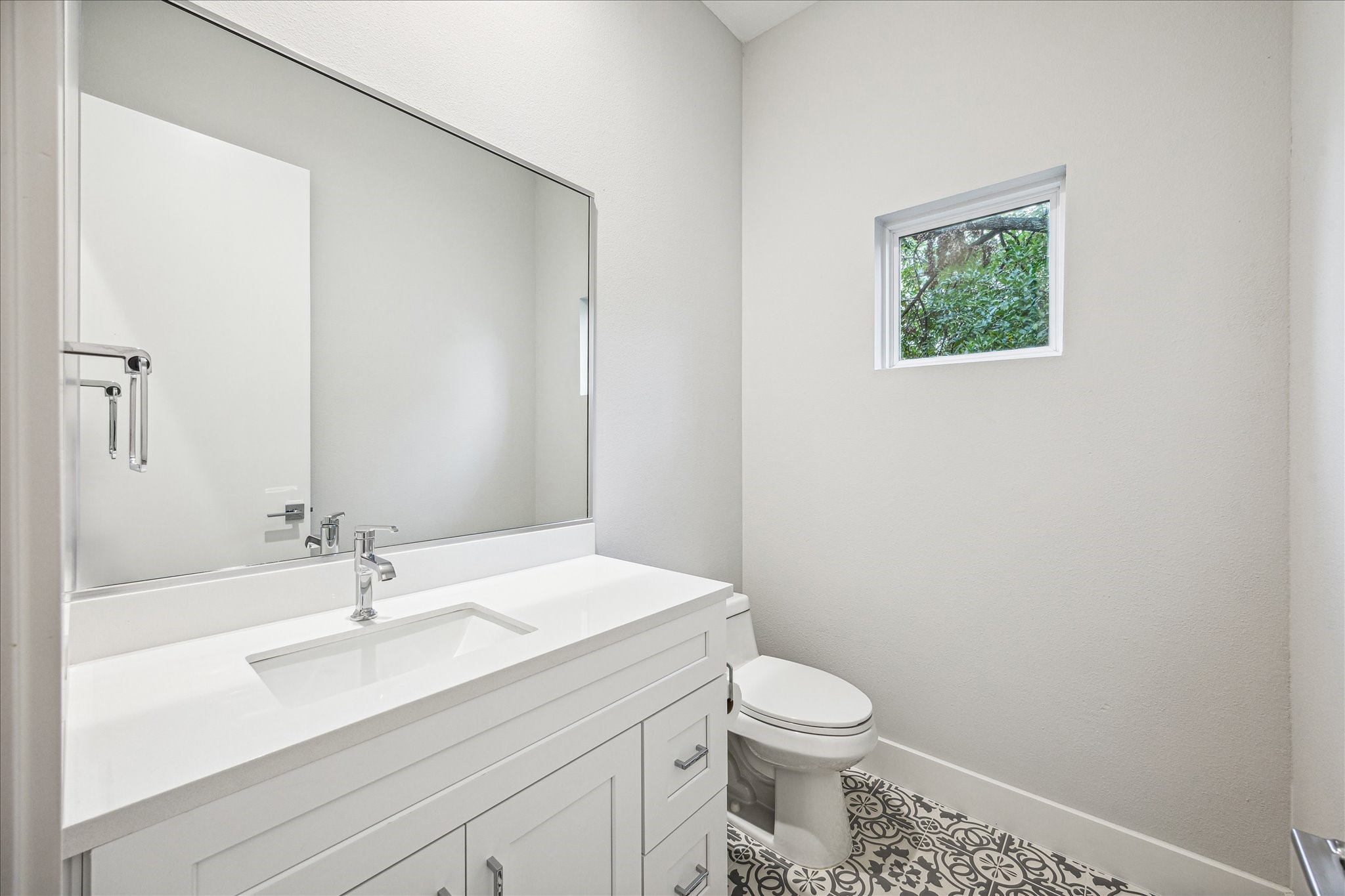 1518 Houston Avenue Houston, TX 77007 - Photo 31 of 40 a bathroom with a granite countertop sink a toilet and a mirror