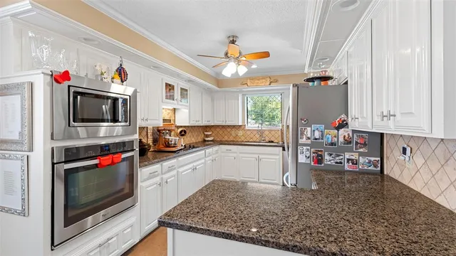 a kitchen with granite countertop a stove a sink and a microwave