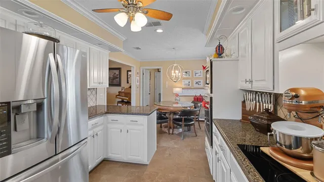 a kitchen with stainless steel appliances granite countertop a refrigerator a stove and a sink with dishwasher