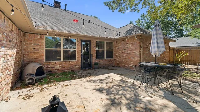 a view of a patio with a table and chairs and wooden fence