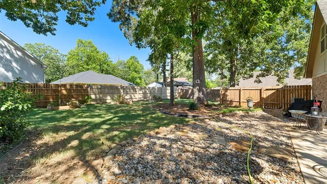 a view of backyard with a table and chairs under an umbrella