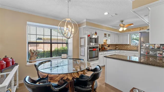 a view of a dining room with furniture a chandelier and wooden floor