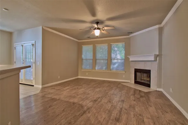a view of an empty room with a fireplace and a window