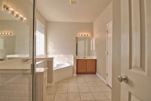 a spacious bathroom with a bathtub and a shower
