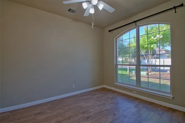 a view of a livingroom with wooden floor and a large window