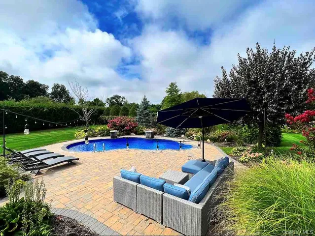 a view of swimming pool with lounge chair and fire pit