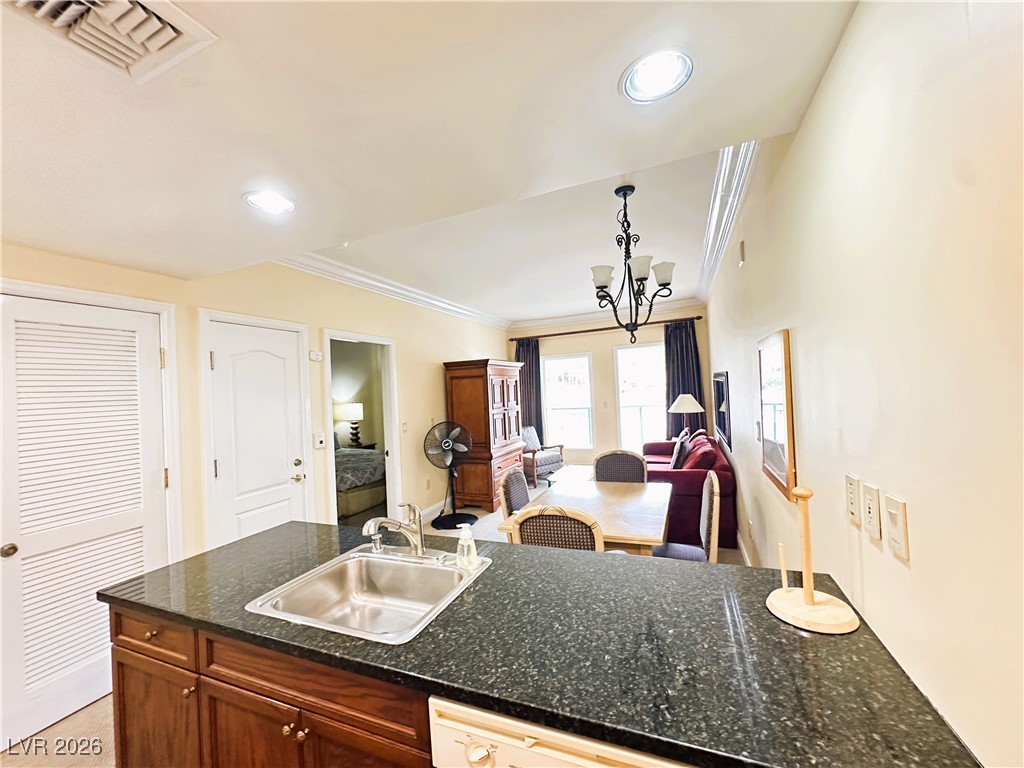 30 Strada Di Villaggio, Unit 531 Henderson, NV 89011 - Photo 40 of 42 Kitchen featuring a chandelier, dishwasher, open floor plan, pendant lighting, and ornamental molding
