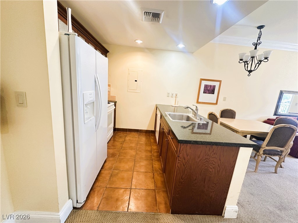 30 Strada Di Villaggio, Unit 531 Henderson, NV 89011 - Photo 21 of 42 Kitchen featuring a peninsula, white appliances, light tile patterned floors, hanging light fixtures, and recessed lighting