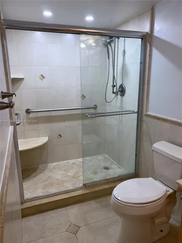 a bathroom with a toilet and a shower