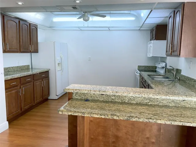 a kitchen with stainless steel appliances granite countertop a sink a stove counter space and cabinets