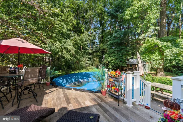 a view of a wooden dinning table and chairs in the garden