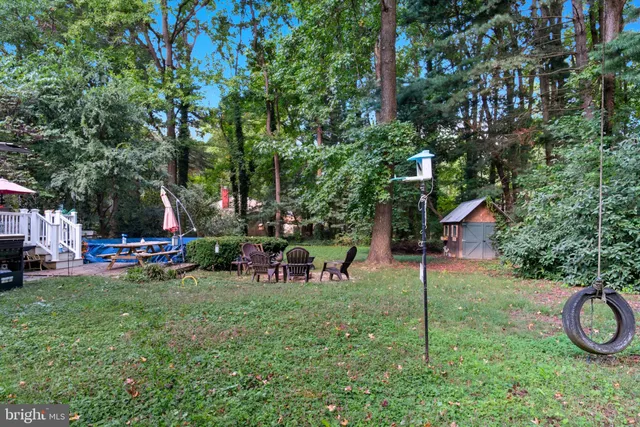a view of a backyard with table and chairs and a large tree